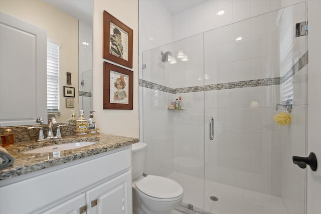 bathroom featuring vanity, toilet, and walk in shower