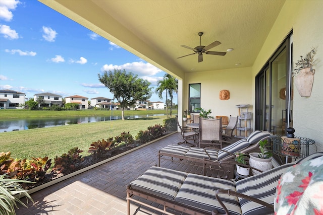 view of patio / terrace with a water view and ceiling fan