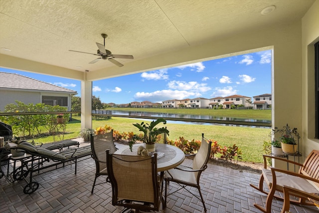 view of patio / terrace featuring a water view and ceiling fan