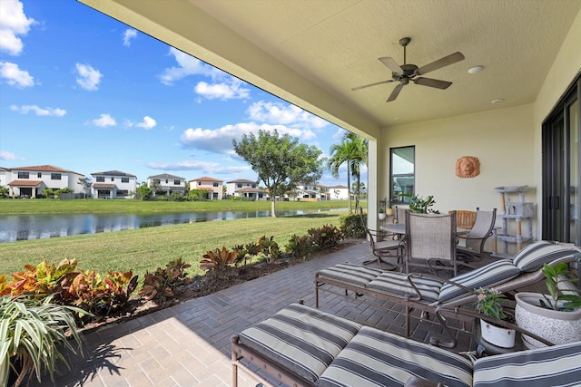 view of patio featuring a water view and ceiling fan