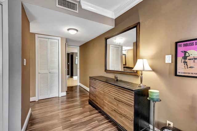 hall with ornamental molding and hardwood / wood-style flooring