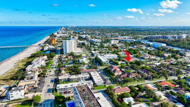 birds eye view of property featuring a water view and a beach view