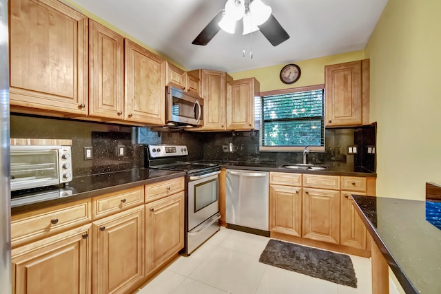 kitchen featuring stainless steel appliances, backsplash, sink, and light tile patterned floors