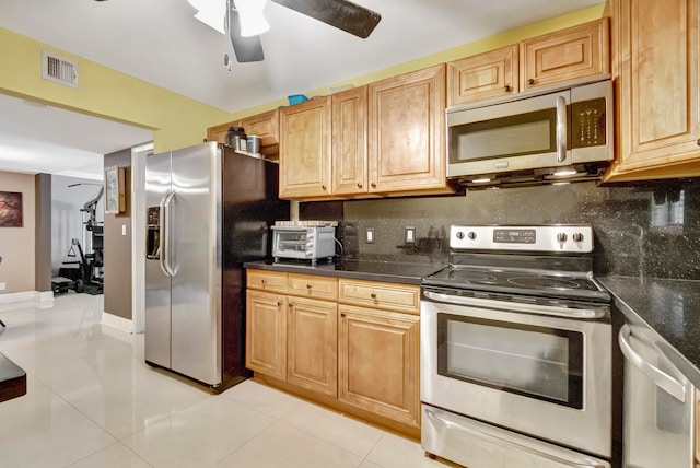 kitchen with tasteful backsplash, appliances with stainless steel finishes, and light tile patterned floors