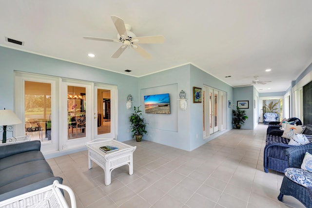 tiled living room with ornamental molding and ceiling fan