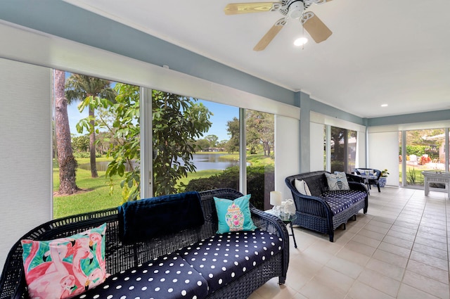 sunroom / solarium featuring a water view and ceiling fan