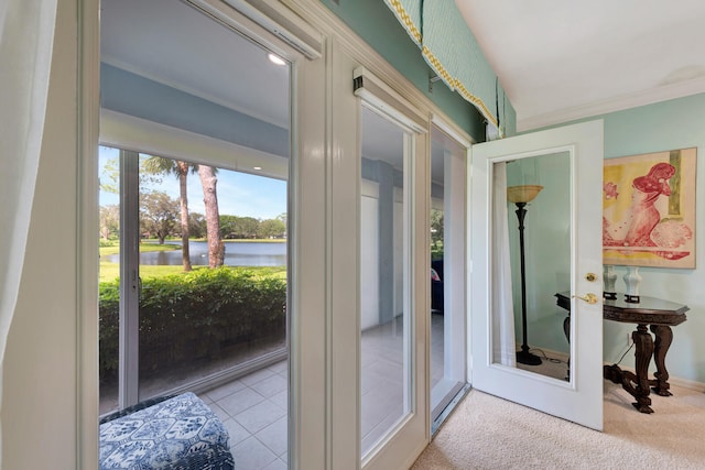 entryway with ornamental molding, a water view, light colored carpet, and french doors