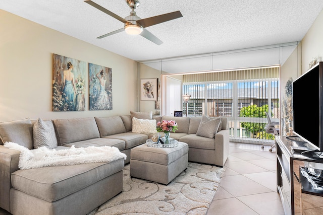 living room with ceiling fan, light tile patterned floors, and a textured ceiling