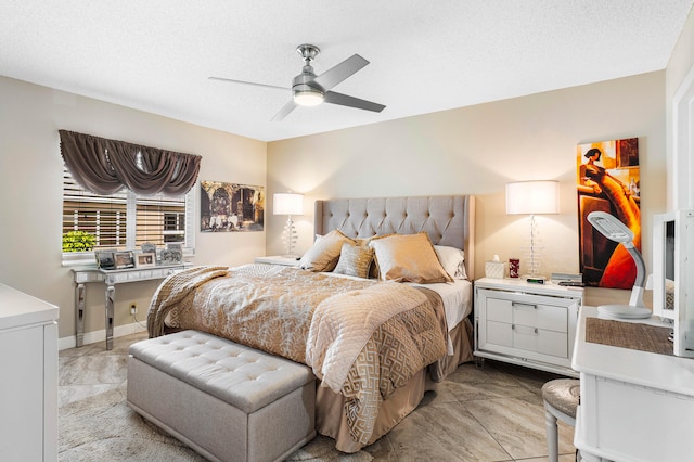 tiled bedroom with ceiling fan and a textured ceiling