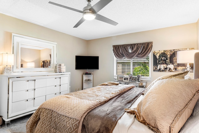 bedroom with ceiling fan and a textured ceiling