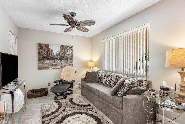 living room with ceiling fan and a textured ceiling