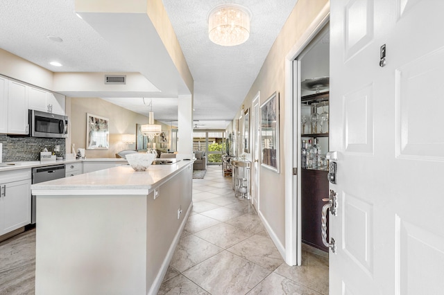 kitchen featuring white cabinetry, stainless steel appliances, and a textured ceiling