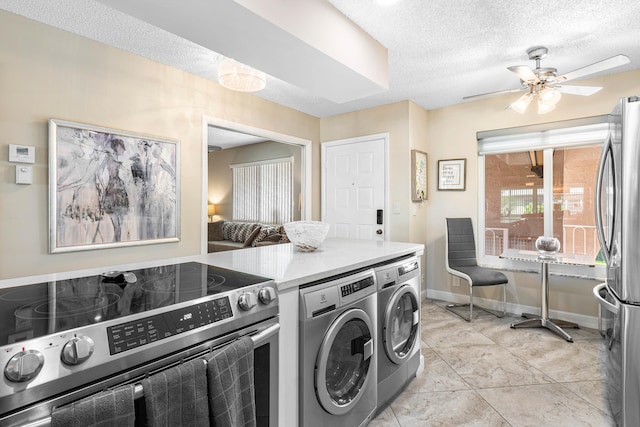 laundry room featuring light tile patterned flooring, washing machine and dryer, and a textured ceiling