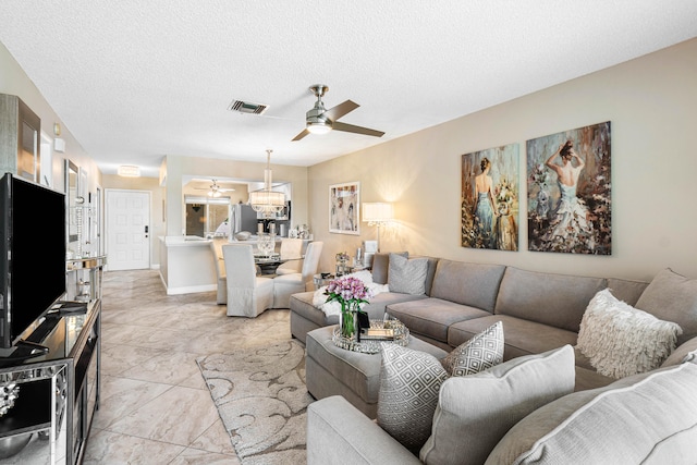 living room with ceiling fan and a textured ceiling