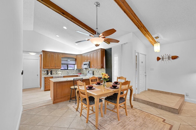 dining space featuring lofted ceiling with beams, light tile patterned floors, ceiling fan, and a textured ceiling