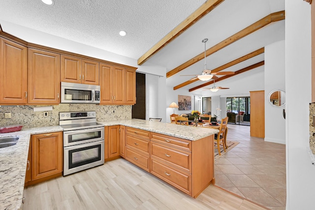 kitchen featuring light stone counters, tasteful backsplash, lofted ceiling with beams, appliances with stainless steel finishes, and a peninsula