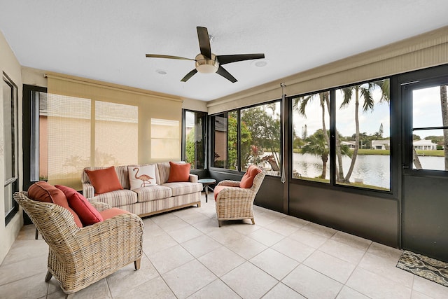 sunroom featuring ceiling fan and a water view