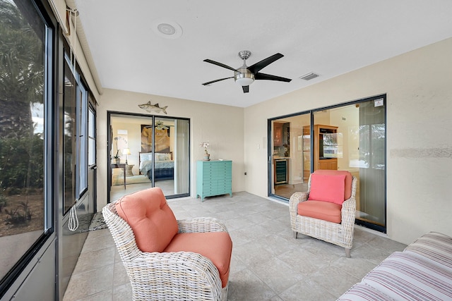 sunroom with ceiling fan, wine cooler, and visible vents