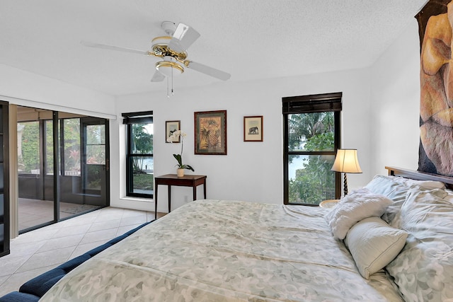 bedroom with access to outside, light tile patterned floors, ceiling fan, and a textured ceiling