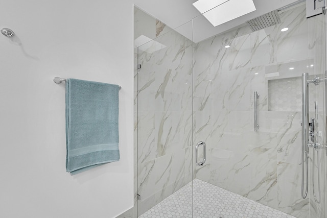 full bathroom featuring a skylight and a marble finish shower