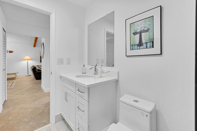 bathroom featuring beam ceiling, vanity, tile patterned floors, and toilet