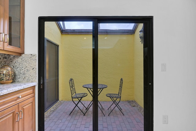 interior space featuring brick floor and a skylight