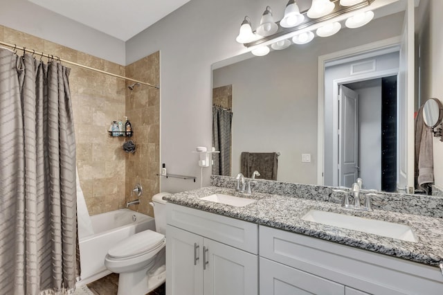 full bathroom featuring toilet, shower / bath combo with shower curtain, and vanity