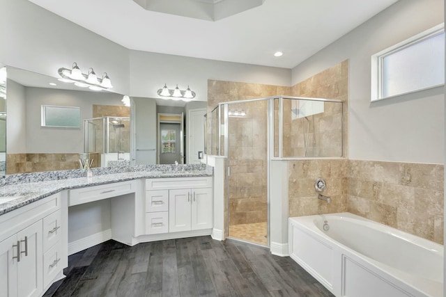 bathroom with independent shower and bath, vanity, and hardwood / wood-style floors