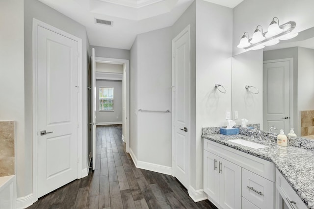 bathroom featuring wood-type flooring, vanity, and a bathtub