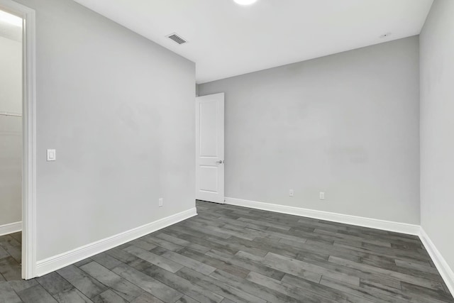 empty room with dark hardwood / wood-style flooring