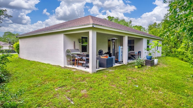 rear view of property with a patio and a yard