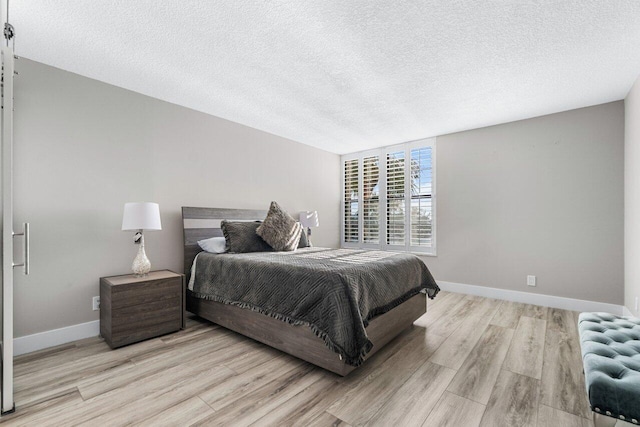 bedroom featuring a textured ceiling and light hardwood / wood-style floors