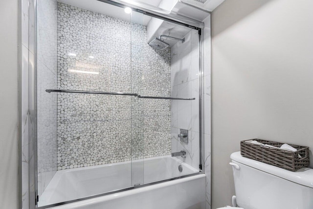 bathroom with combined bath / shower with glass door and toilet