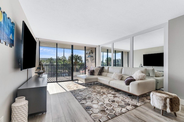 living room with floor to ceiling windows, wood-type flooring, and a textured ceiling