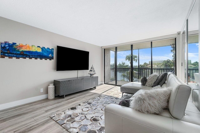 living room featuring wood-type flooring, floor to ceiling windows, and a textured ceiling