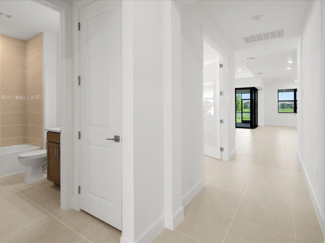 corridor featuring light tile patterned floors