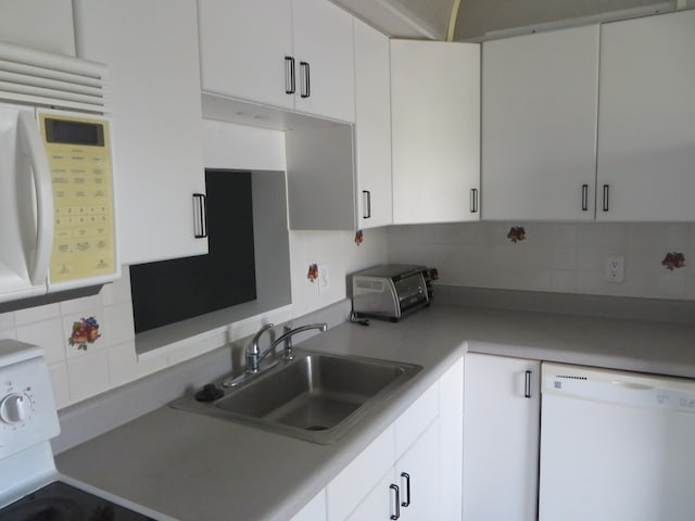 kitchen with white cabinets, backsplash, sink, and white appliances