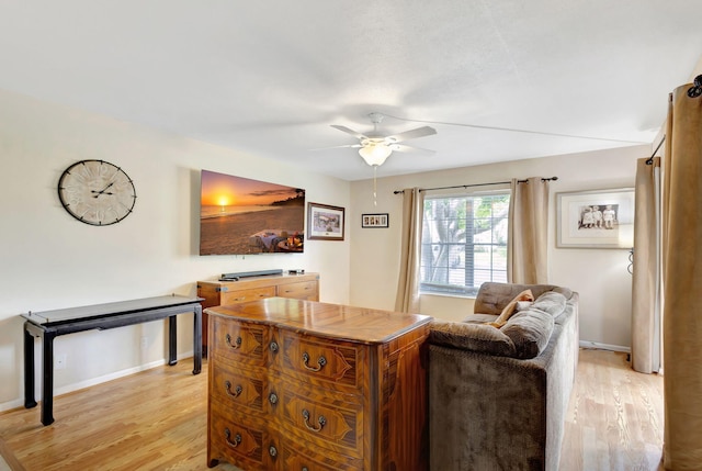 living room featuring light wood-type flooring and ceiling fan