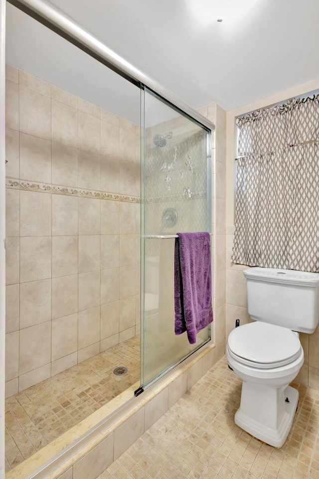 bathroom featuring tile walls, tile patterned floors, toilet, and walk in shower