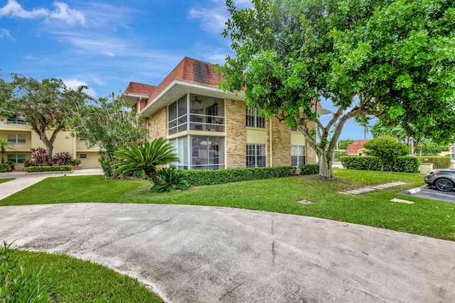 view of front of house featuring a sunroom and a front lawn