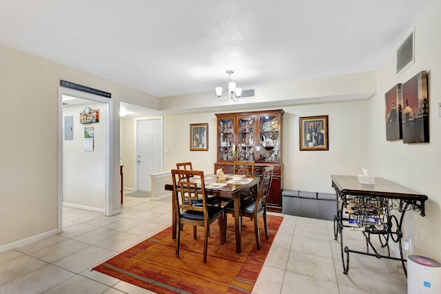 tiled dining room featuring an inviting chandelier