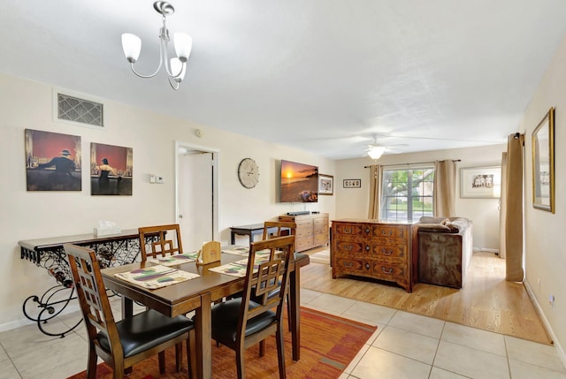 dining area featuring light hardwood / wood-style floors and ceiling fan with notable chandelier