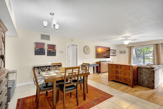 dining area with ceiling fan with notable chandelier and light wood-type flooring