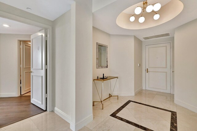 hall featuring a notable chandelier and light wood-type flooring