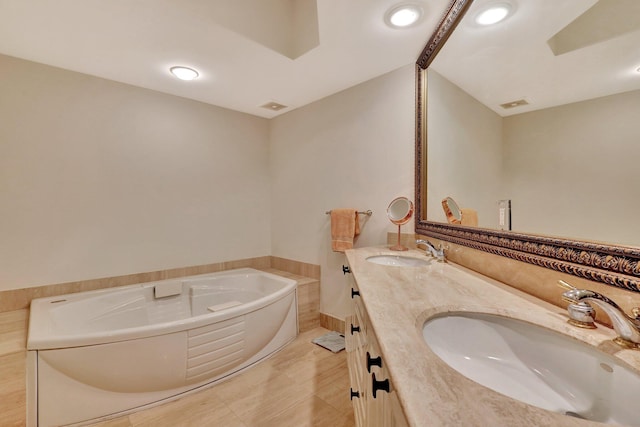 bathroom with vanity and a washtub