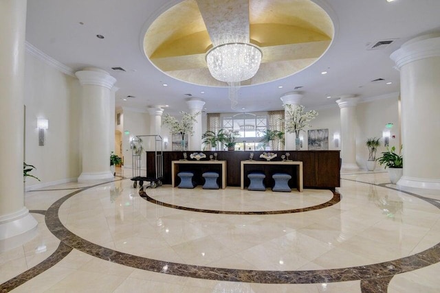 welcome area with ornate columns and an inviting chandelier