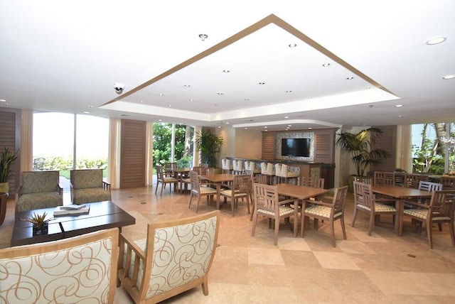 dining room with plenty of natural light and a raised ceiling