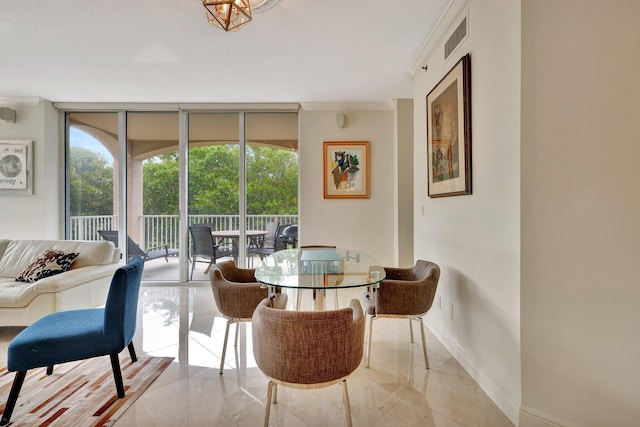 dining room featuring a wealth of natural light, ornamental molding, and a wall of windows