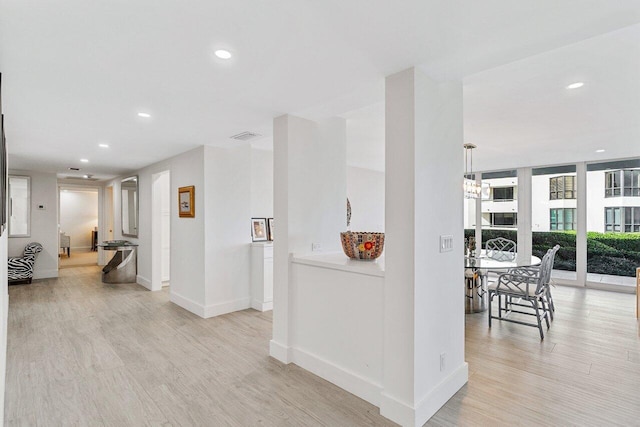 corridor with light hardwood / wood-style floors