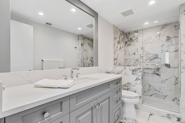 bathroom with vanity, a shower with shower door, and toilet